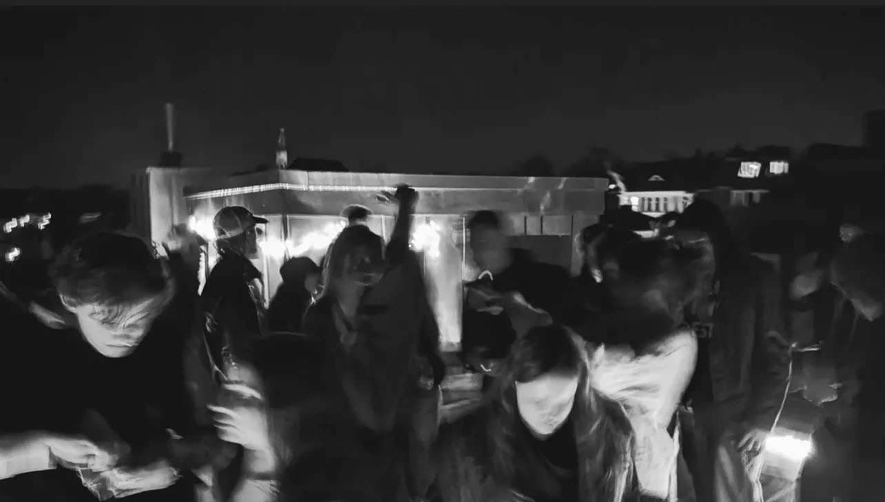 Gäste auf einer CrowdFunction-Dachterrassenparty bei Nacht